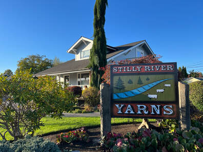 Photo of Stilly River Yarns logo sign and the shop building